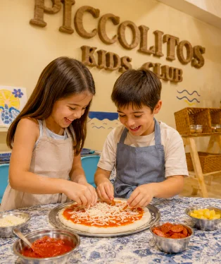 Girl and boy making a pizza at Piccolitos