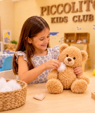 Girl stuffing a teddy bear at Piccolitos
