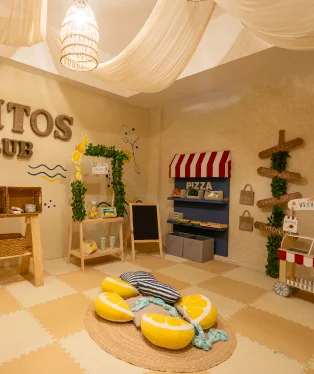 Piccolitos play area with a play kitchen and lemon cushions